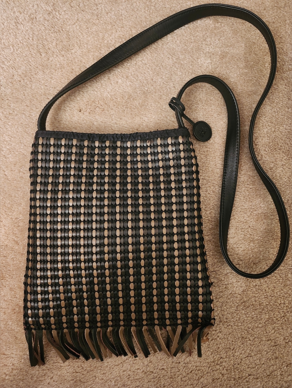The SAK Black/Tan Woven Leather Fringe Crossbody Bag